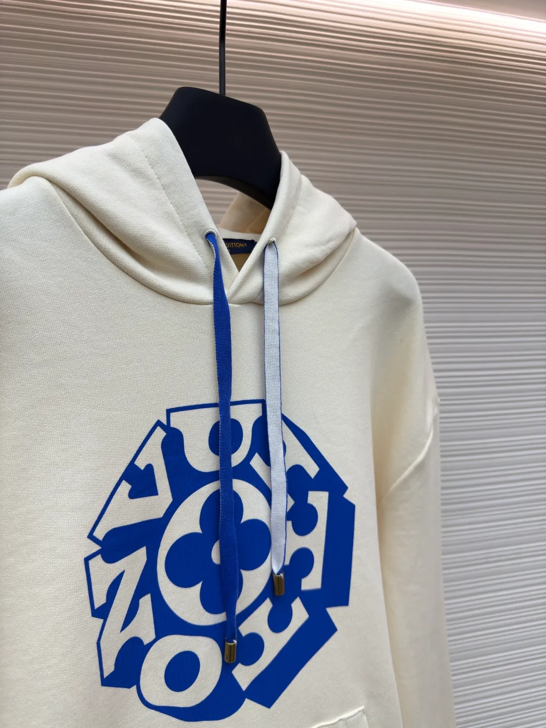 LOUIS VUITTON blue rope floral letter printed hooded sweatshirt ●Authentic product: purchased and developed by 11100 ●Item number: 1680405-A90 ●Fabric: pure cotton knitted fabric ●Technology: printing production ●Version: fitted version ●Weight: about 750 grams ●Size: XS-S-M-L ●Description: Made of 100% cotton knitted fabric, light and breathable, perfect for summer wear. The creamy white body is boldly printed with the blue Vuitton flower pattern from the 2025 autumn and winter show on the front, which contrasts sharply with the background color. The specially designed blue rope strap is paired with an antique gold metal top that echoes the tones of the print. The sweatshirt has a loose, one-size-fits-all fit, with comfortable ribbing at the waist and hem. It features the signature co-branded print on the chest and practical large pockets on the sides. The overall design not only retains the casual feel of streetwear, but also incorporates classic Louis Vuitton elements. It shows a unique fashion attitude through exquisite printing technology and exquisite detail processing. The cotton fabric ensures wearing comfort, while the fine printing process ensures the lasting vividness of the pattern. The overall wiring is straight and delicate, the fabric is comfortable and soft, and the color is consistent without color difference. It can be matched with the same style to create a fashionable look and control various occasions. Customized accessories, complete with three standards, same style for men and women!
